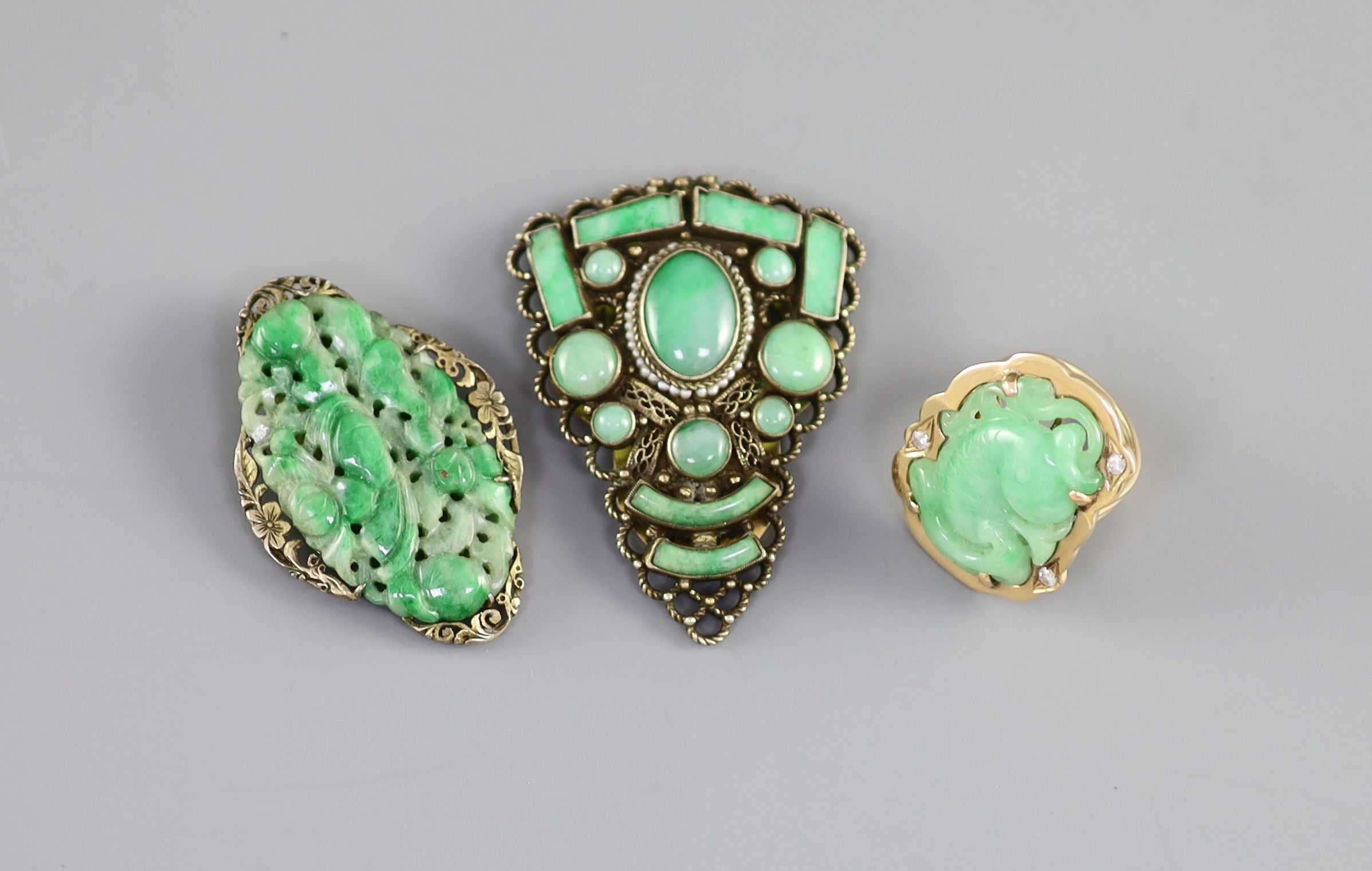 Two Chinese jadeite and gilt metal clips, first half 20th century and a yellow metal jadeite ‘fish’ ring, late 20th century, Clips 4.5 and 5cm